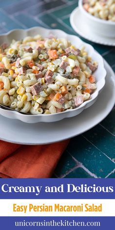 two white plates filled with pasta salad on top of a blue and orange table cloth