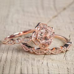 a close up of a ring on top of a piece of wood with an oval shaped diamond in the center