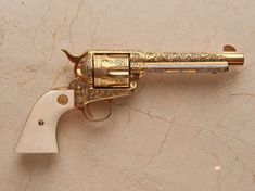 an antique brass revolver on a marble surface