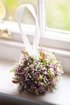 a bridal bouquet sitting on top of a window sill next to a window