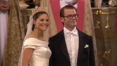 a man and woman standing next to each other in front of a wedding ceremony backdrop