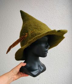 I made this hat from green wool using the felting method in the form of Snufkin's hat. The hat has an uneven, torn edge and is decorated with a single feather. Made to order within 2-3 days, there may be minimal differences in the color of the feather and the relief of the edge of the hat from what is shown in the photo.    Brim diameter 35 cm. Please write your phone number in the notes to your order if you would like it to be included on the package along with your address. Ren Faire Hat, Fairycore Home, Gnome Costume, Hat With Feather, Wizard Hat, Feather Headpiece, Hat Fedora, Felted Art, Felt Hats