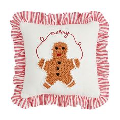 a red and white pillow with a teddy bear embroidered on the front that says merry