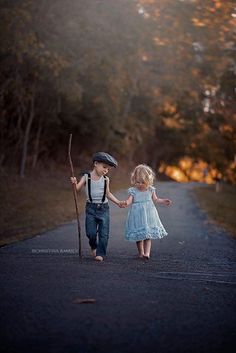 two children walking down a road holding hands