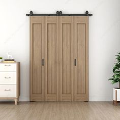 an empty room with a white dresser and wooden closet doors on the wall next to a potted plant