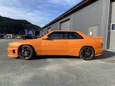 an orange car parked in front of a building