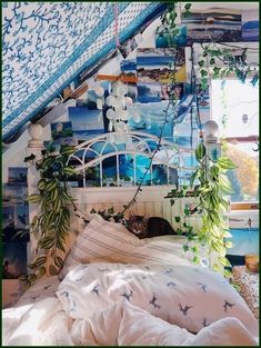 an unmade bed with blue and white wallpaper in a room that has plants growing on the walls