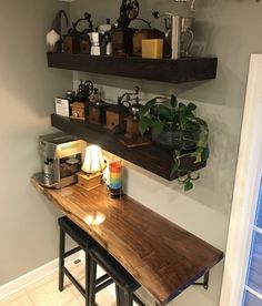 two shelves above a counter with various items on it and a potted plant in the corner