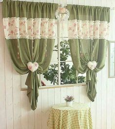 a window with green curtains and pink flowers on the valance, next to a checkered table cloth