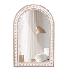 a mirror that is on the wall with a lamp next to it and a pillow