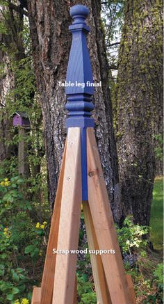 a wooden easel stands in front of a tree with the words table leg final