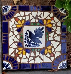 a blue and white tile with an image of a bird on it's side