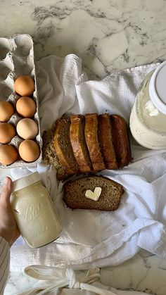 bread, eggs and butter on a towel next to a carton of yogurt