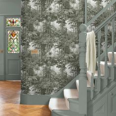 a wallpapered staircase leading up to a stained glass window