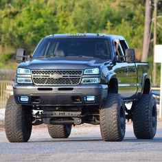 a large black truck driving down a street