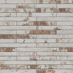 a white brick wall with rusted paint on it's sides and brown spots