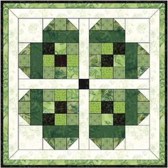 a green and black quilt with four squares on the front, one in the center