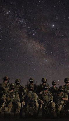 the soldiers are posing for a photo under the night sky