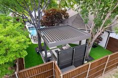 an aerial view of a house with a pool in the back yard and fence surrounding it