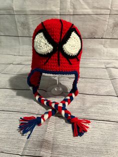 a crocheted spiderman hat with red, white and blue stripes on it