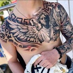 a man with tattoos on his chest holding a cell phone