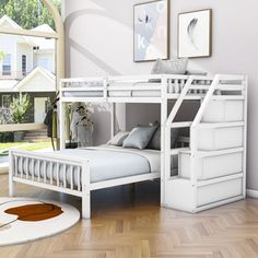 a white bunk bed sitting on top of a hard wood floor next to a window