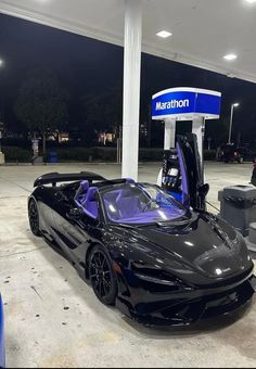 a black sports car parked at a gas station