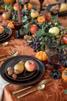 the table is set with fruit and silverware for an elegant thanksgiving dinner or brunch