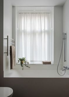 a bathroom with a tub, shower head and window