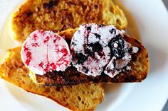 two pieces of toast on a plate with jelly and cranberry spread over them