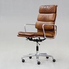 a brown leather office chair sitting on top of a metal base