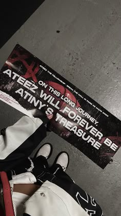 a pair of white and black shoes sitting on top of a floor next to a sign