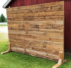 a wooden fence sitting next to a red barn