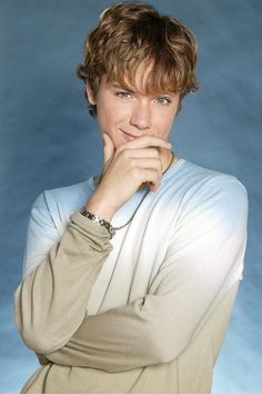 a young man posing for a photo with his hand on his chin