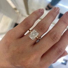 a woman's hand with a diamond ring on it