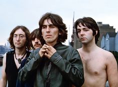 a group of young men standing next to each other in front of a body of water