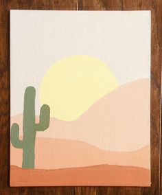 a painting of a cactus and the sun in the distance on a wooden table top