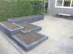 an outdoor garden area with raised planters and benches on the side of the building