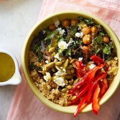 a yellow bowl filled with food next to a cup of olive oil on a pink napkin