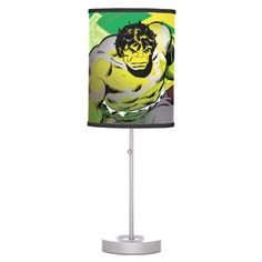 the incredible hulk lamp on a white base with a green and yellow shade over it