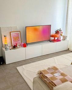 a flat screen tv sitting on top of a white entertainment center