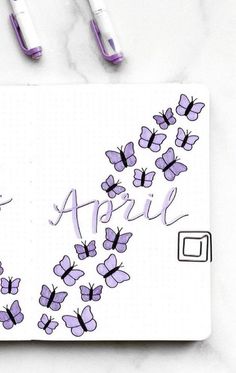 a notepad with purple butterflies and the word april written in cursive writing