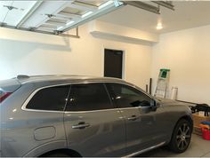 a grey car parked in a garage next to a wall mounted air freshener dispenser