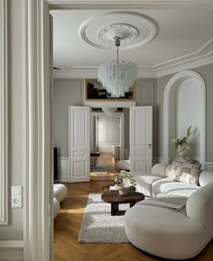 a living room filled with furniture and a chandelier