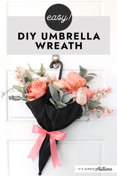 an umbrella wreath hanging on the front door with pink flowers and greenery in it