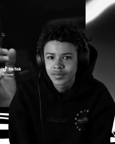 a young man wearing headphones in front of a computer screen with the words tik tok on it