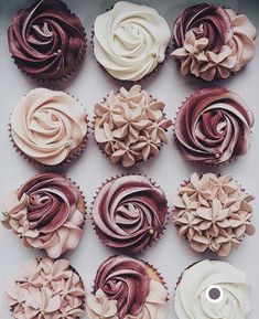 twelve cupcakes with pink and red frosting on them are arranged in rows