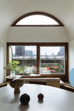 a living room with large windows and a white table in front of the couches