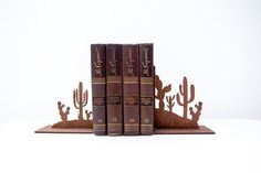 three bookends made out of wood with books in the shape of cacti