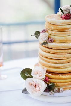 a stack of pancakes sitting on top of a white plate covered in frosting and flowers